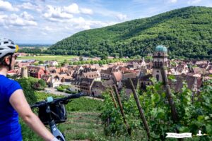 Ciclista mirando el pueblo de Kaysersberg en Alsacia
